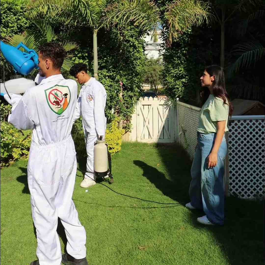The Formax team spraying a villa garden while the homeowner watches